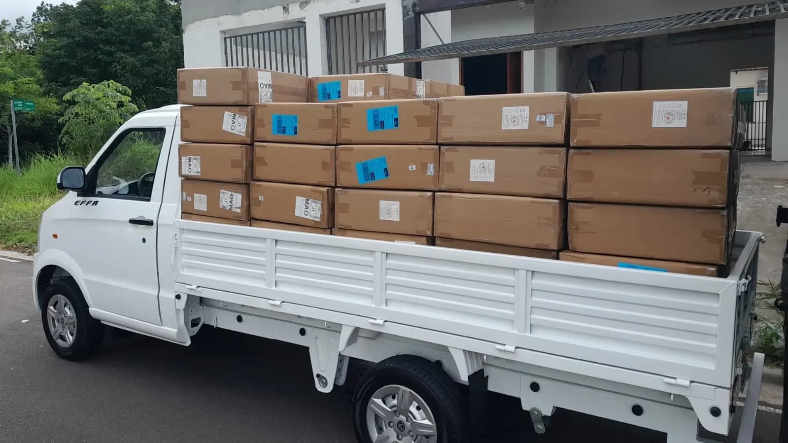 Picape V21 com a caçamba cheia de caixas de papelão empilhadas