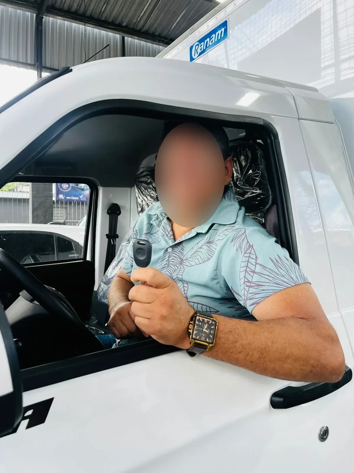 Cliente ao volante do Effa novo, mostrando a chave pela janela