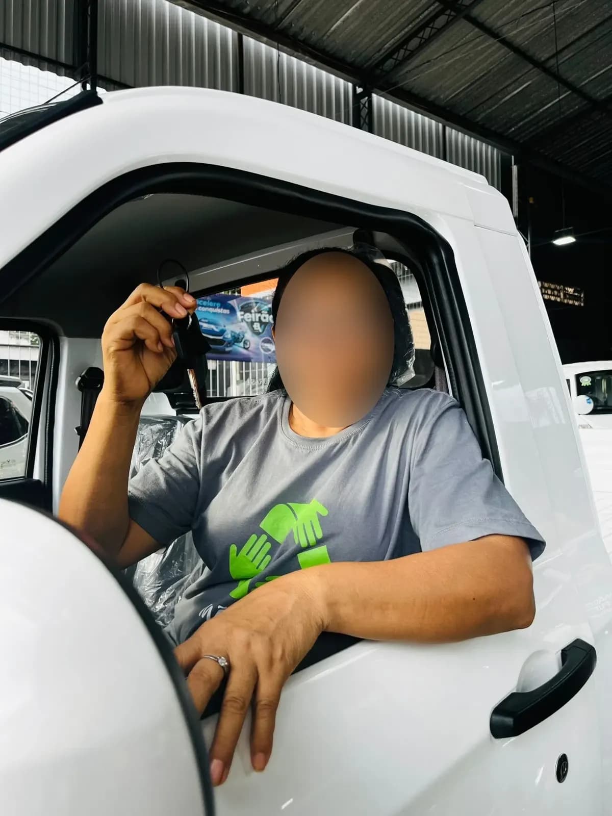 Cliente ao volante do Effa novo, mostrando a chave pela janela