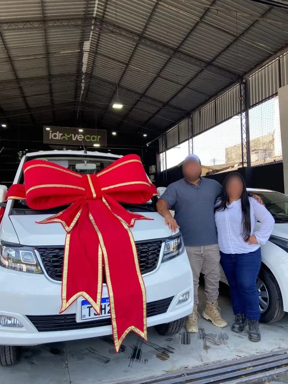 Casal de clientes ao lado do Effa com um grande laço vermelho