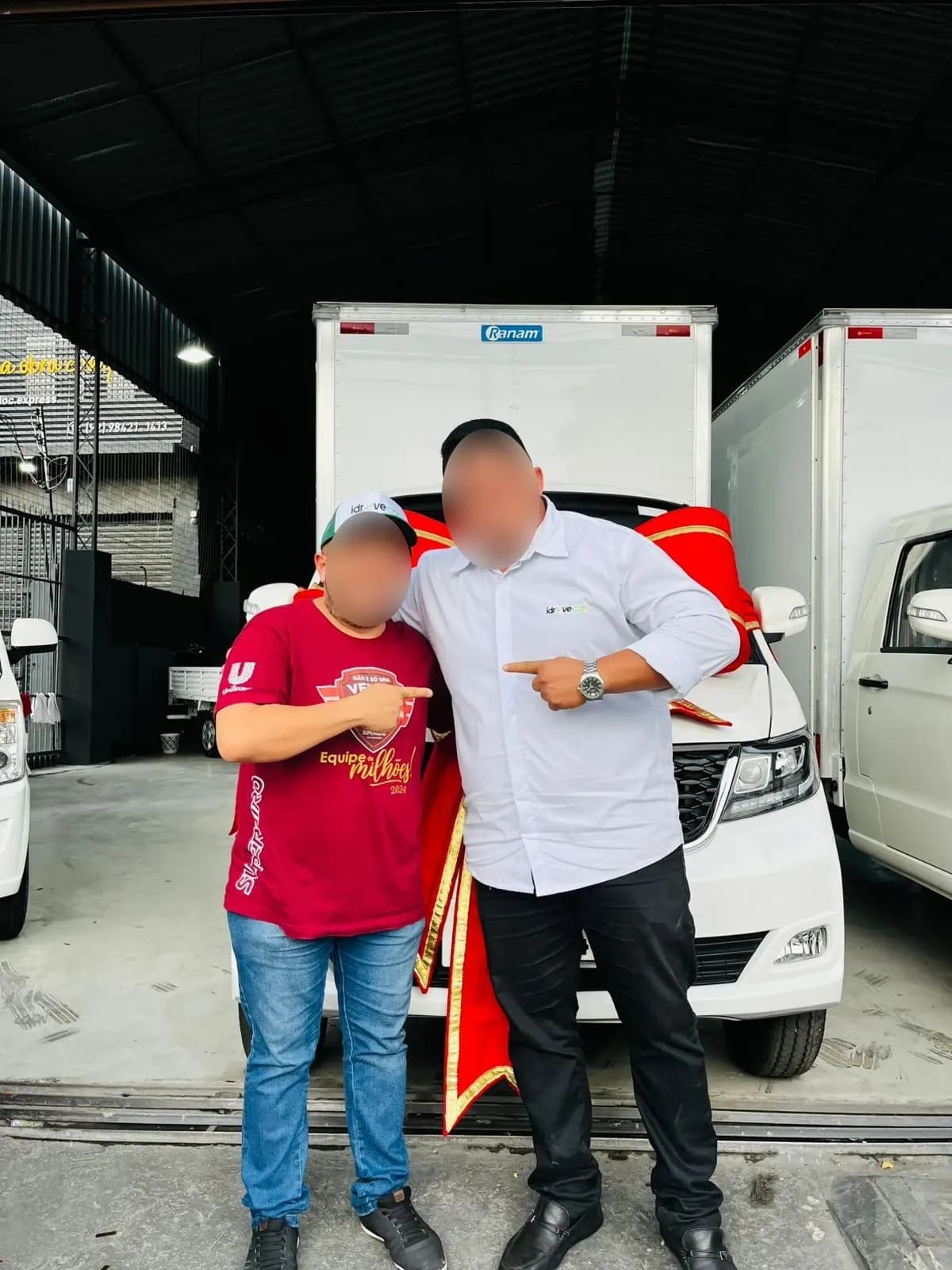 Cliente e vendedor comemoram em frente ao Effa com laço vermelho