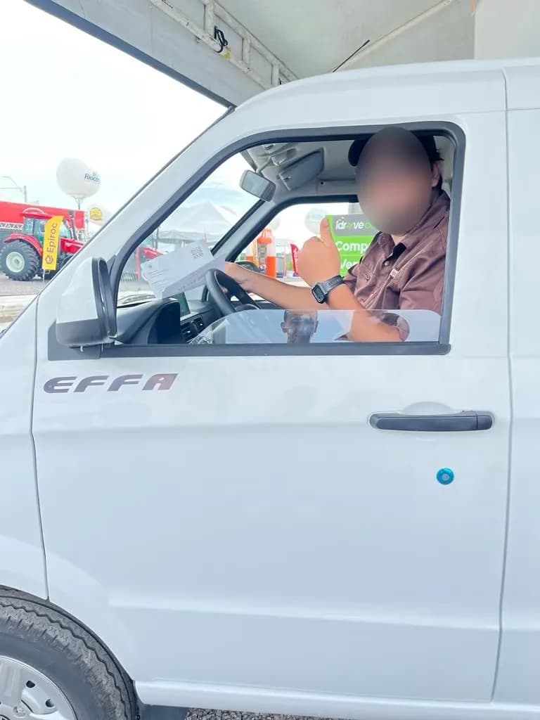 Cliente sorri ao volante do Effa, com o polegar para cima
