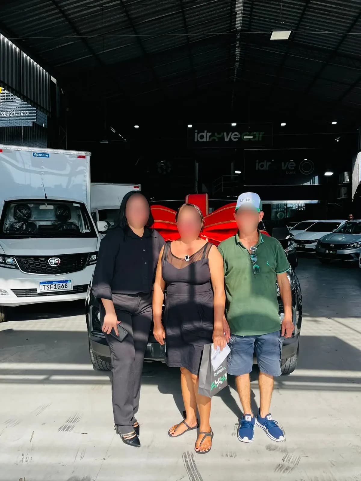 Família de clientes em frente ao Effa com laço vermelho